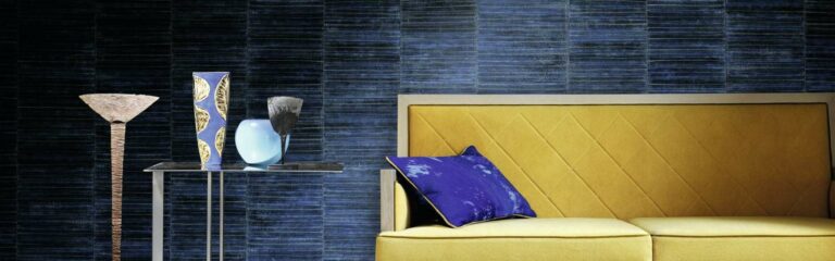 Ein gelb-blauer Stuhl vor einer blauen Wand. Lauer maler & raumdesign - Bodenbeläge, Vinylboden, Farben, Sonnenschutz, Malerarbeiten - Bahnhofstr. 5a - 36280 Oberaula